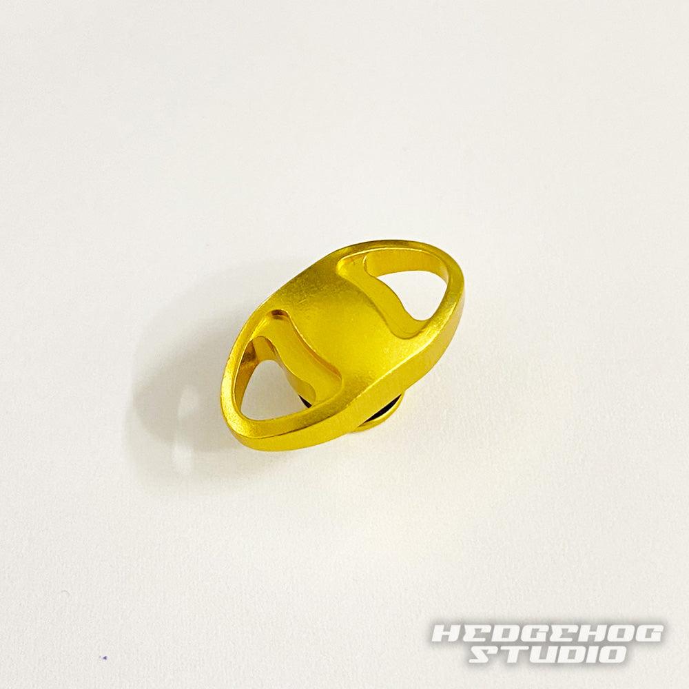 Eine kleine, metallisch-goldene Hedgehog Studio Knopfkappe mit zwei ovalen Öffnungen für Shimano 20 Metanium, 22 Metanium Shallow Edition und 20 SLX DC ist auf weißem Untergrund abgebildet. Das Wasserzeichen „HEDGEHOG STUDIO“ erscheint in der unteren rechten Ecke des Bildes.