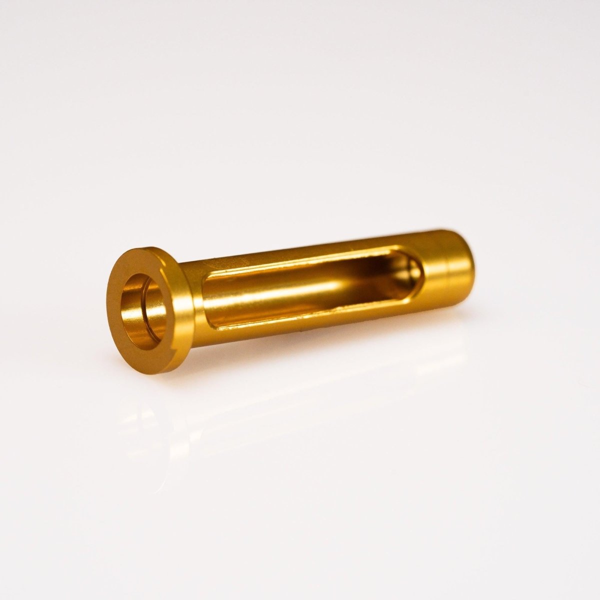 Eine zylindrische, metallisch goldene Komponente aus dem Wormshaft Level Wind Pipe Set von Hedgehog Studio für Shimano Metanium & Bantam mit einem Flanschende und einem langen seitlichen Ausschnitt, dargestellt auf einem weißen Hintergrund.