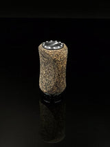 Der RL-TNG Korkknopf 20 mm | Slim | Universal Fit von RL-Angelrollentuning verfügt über eine zylindrische, gesprenkelte braune Korkoberfläche und eine schwarze Oberseite mit weißen Punkten, die vor einem durchgehend schwarzen Hintergrund dargestellt sind.