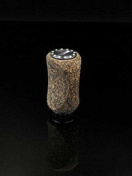 Der RL-TNG Korkknopf 20 mm | Slim | Universal Fit von RL-Angelrollentuning verfügt über eine zylindrische, gesprenkelte braune Korkoberfläche und eine schwarze Oberseite mit weißen Punkten, die vor einem durchgehend schwarzen Hintergrund dargestellt sind.