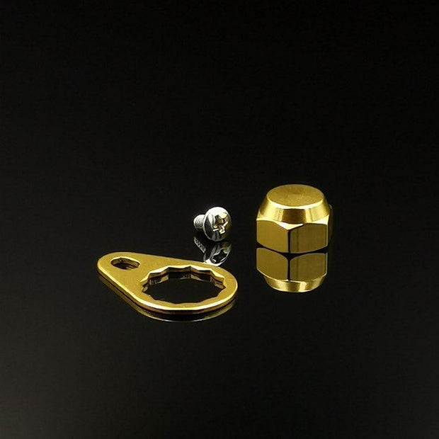 Auf schlichtem, schwarzem Untergrund sind eine goldene Kontermutter inkl. Plättchen (M7) von RL-Angelrollentuning, ein passender goldener Schraubenschlüssel und eine kleine silberne M7 Schraube abgebildet.