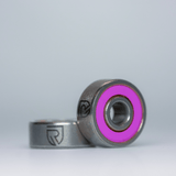 Zwei RL-Angelrollentuning RL-TNG Hybrid Keramik Kugellager (ABEC 9, 3x7x3) für Shimano sind mit einer leuchtend pinken Gummidichtung und "R"-Logo abgebildet - ideale Upgrades für BFS Rollen.