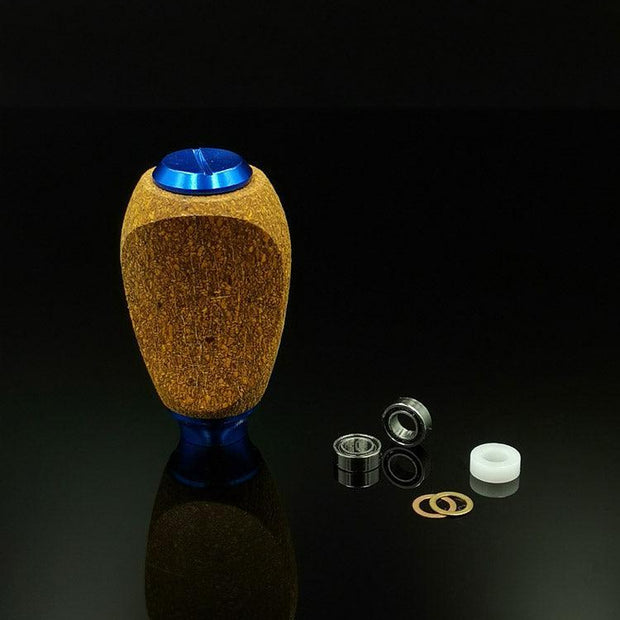 Der RL-TNG Kork Knob von RL-Angelrollentuning steht aufrecht auf einer glänzend schwarzen Oberfläche und verfügt über Metalllager, Unterlegscheiben und einen weißen Kunststoffzylinder – unverzichtbare Teile zum Tunen Ihrer Angelrolle. Universelle Passform in mehreren Farben.