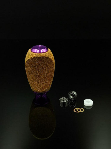 Der RL-Angelrollentuning RL-TNG Kork Knob (mehrfarbig, universell passend) steht aufrecht auf einer schwarzen Fläche, daneben befinden sich zwei Metalllager, ein Kunststoffring und zwei Unterlegscheiben – ideale Komponenten zum Aufrüsten Ihrer Angelrolle.