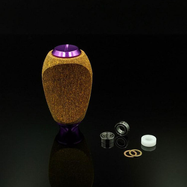 Der RL-Angelrollentuning RL-TNG Kork Knob (mehrfarbig, universell passend) steht aufrecht auf einer schwarzen Fläche, daneben befinden sich zwei Metalllager, ein Kunststoffring und zwei Unterlegscheiben – ideale Komponenten zum Aufrüsten Ihrer Angelrolle.