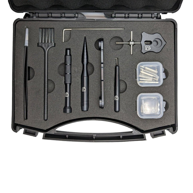 Das RL-TNG Wartungskit Werkzeugkoffer für Baitcaster-Angelrollen von RL-Angelrollentuning umfasst Bürste, Werkzeuge, Schraubenschlüssel und Behälter – alles ordentlich organisiert in einem schwarzen Schaumstoffkoffer, ideal für die Rollenwartung.