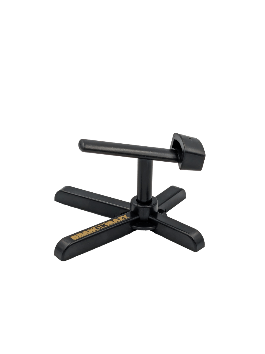 Der Röllenständer DK | Reel Stand von RL-Angelrollentuning ist ein schwarzer, kreuzförmiger Organizer aus Kunststoff mit zentralem Drehmechanismus und QUICKPLAY in Gelb – perfekt für Ihre Baitcasterrolle.