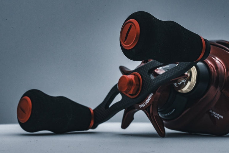 Nahaufnahme des RL-TNG OCT 24 EVA Knob-Griffs von RL-TNG mit langlebigen EVA-Griffen und auffälligen roten Akzenten, befestigt an einem metallischen Rollengehäuse vor einem neutralen grauen Hintergrund.