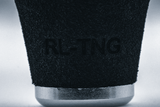 Nahaufnahme des RL-TNG OCT 24 EVA-Knopfes von RL-TNG mit strukturierter schwarzer Oberfläche, eingraviertem Branding und einem metallisch-silbernen Band an der Unterseite. Hergestellt aus EVA-Material für maximalen Halt, vor neutralem Hintergrund.