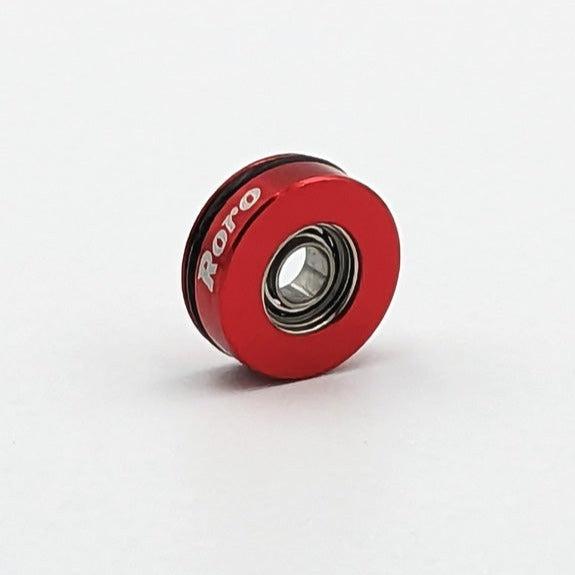 Ein kleines, rundes, rotes Metalllager mit dem Schriftzug 