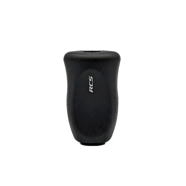 Ein schwarzer, zylindrischer SLP Works RCS i-Shape Korkknopf mit leicht gebogener Form und weißen, vertikal gedruckten RCS-Buchstaben vorne-perfekt für Daiwa Angeln Casting und Spinning Angelrollen, präsentiert auf weißem Hintergrund.