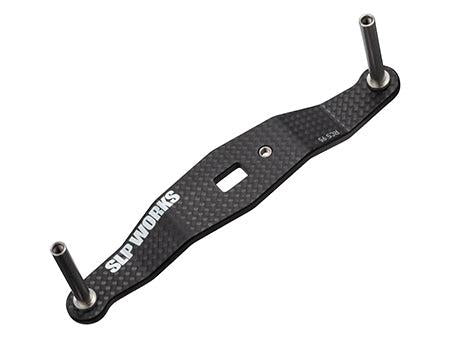 Die SLP Works Carbon-Kurbel (8x5mm, ohne Knöpfe) verfügt über eine schwarze Kohlefaserhalterung mit zwei Metallpfosten, einer zentralen rechteckigen Aussparung und SLP Works-Branding - ideal für Baitcasting-Rollen.