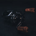 Nahaufnahme einer dunklen, schicken Baitcaster-Rolle mit den legendären SLP Works i Shape Wood Knob Limited Edition Griffen – edles Holz trifft cooles Metall! Das Ganze auf einem stylisch-texturierten Hintergrund, Licht bringt die feinen Details der Holzgriffe und die sexy Kurven Ihrer Tuning-Rolle perfekt zur Geltung. Perfekt für alle, die aus ihrer Angelrolle das Maximum rausholen wollen!.
