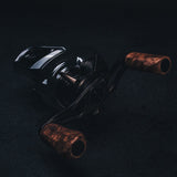 Nahaufnahme vom SLP Works i Shape Wood Knob Limited Edition – der stylische Holzgriff für deine Angelrolle! Hier liegt er richtig cool auf dunklem Untergrund, perfekt in Szene gesetzt mit dramatischer Beleuchtung. Das Must-Have für alle, die ihre Rolle individuell tunen und aus jedem Angeltag ein echtes Highlight machen wollen!.