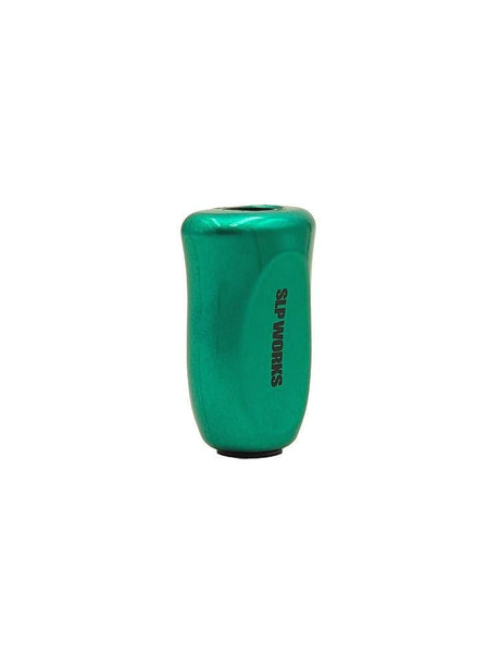 Ein kleiner, metallisch grüner SLP Works i-Type Korkknopf mit einer leicht gebogenen zylindrischen Form und "SLP WORKS" vertikal auf der Seite aufgedruckt, vor einem weißen Hintergrund. Ideal für die Verwendung mit Spinning Angelrollen.