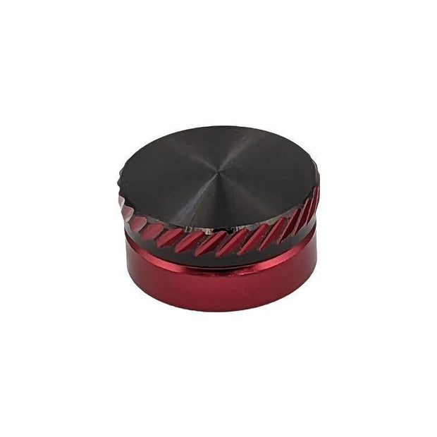 Das kleine, runde SLP Works MC-Nullstellungsset von SLP Works in der Farbe Rot hat diagonale Seitenrillen und eine glatte, reflektierende schwarze Oberseite. Er steht mittig auf einem weißen Hintergrund und ähnelt dem Einsteller für Daiwa Baitcasting-Rollen.