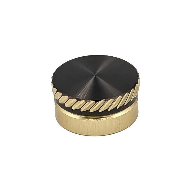 Das SLP Works MC Zero Adjuster Set von SLP Works hat einen runden, goldfarbenen Metallknopf mit schwarzer Oberseite und diagonalen Rillen. Ideal für Daiwa Baitcasting-Rollen. Fotografiert auf einem schlichten weißen Hintergrund.