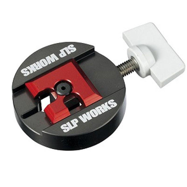 Der SLP Works Spool BB Remover II ist ein rundes, schwarz-rotes Metallwerkzeug mit einem weißen T-förmigen Einstellknopf und gefräster roter Mitte - ideal für Baitcasting-Rollen, von SLP Works.