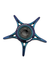 Ein blauer und blaugrüner fünfspeichiger sternförmiger SLP Works Zaion Star Drag aus Metall für Daiwa-Rollen, beschriftet mit "ZL ALON STAR DRAG" und "SUPORMS", ist von oben vor einem weißen Hintergrund zu sehen.