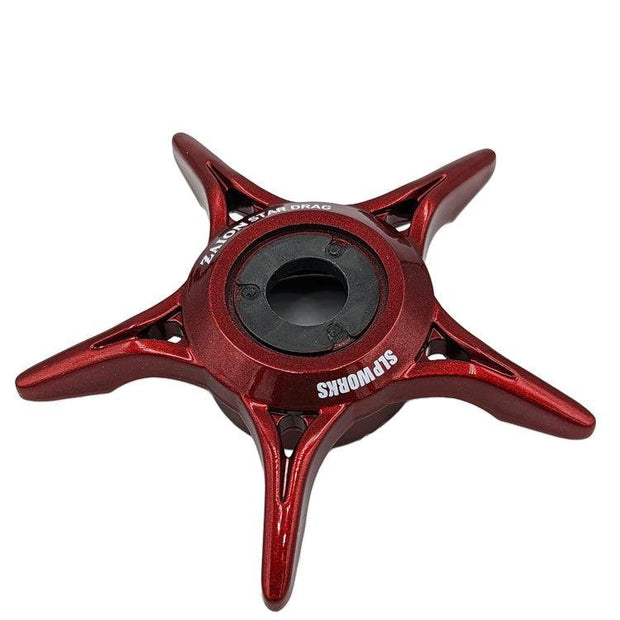 Eine rote SLP Works Zaion Star Drag mit fünf Zinken und einem schwarzen, runden Zentrum aus Zaion-Material liegt auf weißem Untergrund. Das weiße „SLP Works“-Logo erinnert an die Designs der Daiwa Angelrollen-Komponenten.