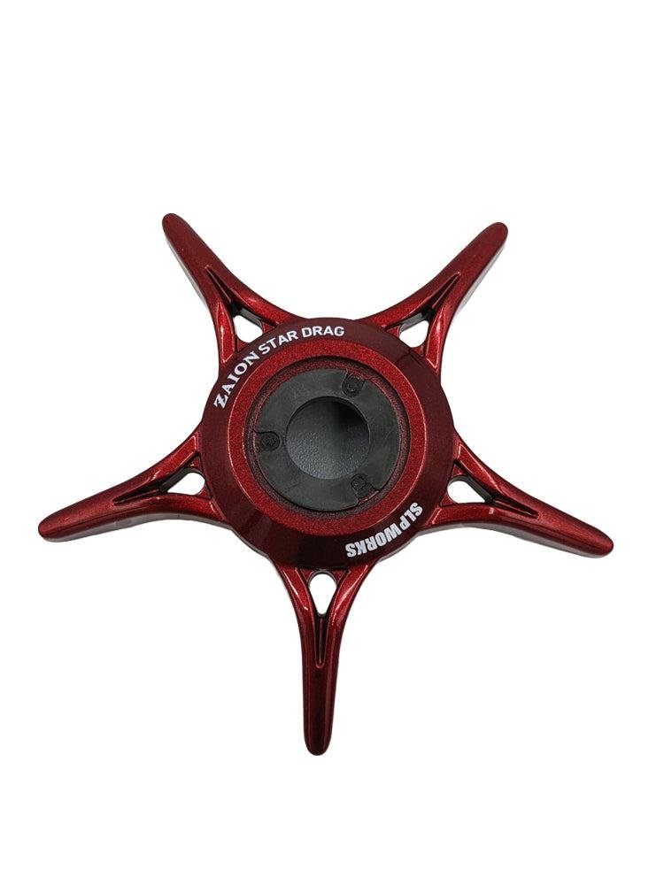 Ein rotes, fünfzackiges, sternförmiges SLP Works Zaion Star Drag Metallteil von SLP Works, von oben auf weißem Hintergrund dargestellt. Entworfen für Daiwa-Rollen mit Zaion Star Drag Technologie.