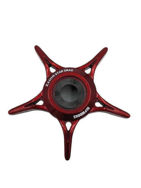 Ein rotes, fünfzackiges, sternförmiges SLP Works Zaion Star Drag Metallteil von SLP Works, von oben auf weißem Hintergrund dargestellt. Entworfen für Daiwa-Rollen mit Zaion Star Drag Technologie.