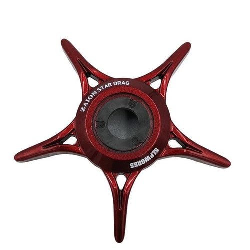 Ein rotes, fünfzackiges, sternförmiges SLP Works Zaion Star Drag Metallteil von SLP Works, von oben auf weißem Hintergrund dargestellt. Entworfen für Daiwa-Rollen mit Zaion Star Drag Technologie.