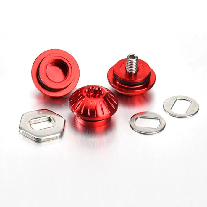 Drei rote Gomexus Aluminiummuttern (rot) mit Gewindebolzen, eine davon mit Kontermutter, sind neben zwei silbernen Sechskant- und zwei Ovalscheiben abgebildet – allesamt passend für Gomexus-Griffe und auf weißem Untergrund präsentiert.