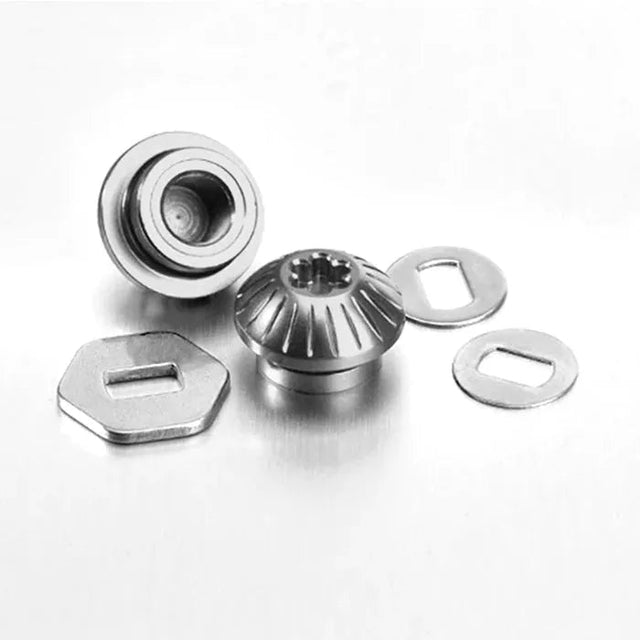 Zwei Gomexus Aluminiummuttern in Silberfarbe sind neben drei flachen Unterlegscheiben mit rechteckigen Schlitzen platziert, alles auf einer schlichten, hellen Oberfläche angeordnet.