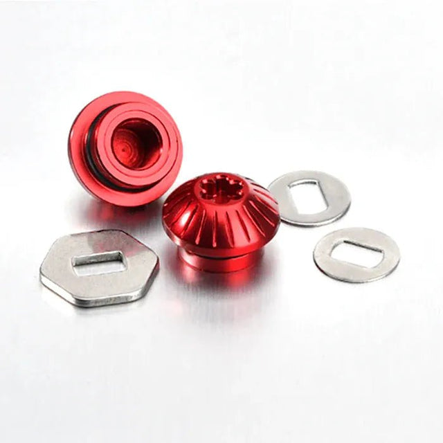 Zwei rote Gomexus Aluminiummuttern mit geriffelten Kanten werden mit flachen silbernen Unterlegscheiben und sechseckigen Platten präsentiert, alles auf einer metallischen Oberfläche – ideal zum Aufrüsten Ihrer Angelrolle mit stilvollen, langlebigen Teilen von Gomexus.