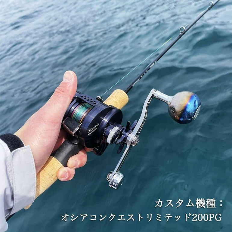 Eine Person hält eine Angelrute mit einer Stationärrolle, die mit dem Gomexus Balance Power Handle 7x4mm ausgestattet ist, über blaues Wasser; der japanische Text unten rechts identifiziert das Produkt und die Marke als Gomexus.