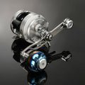 Eine silberne Gomexus Balance Power Handle 7x4mm Baitcastingrolle mit einem Titan-Power-Knopf und einem metallischen, mehrfarbigen Balance-Griff ruht auf einer glänzend schwarzen Oberfläche, ihr zylindrischer Körper ist mit im Licht reflektierenden Einstellknöpfen und Schrauben versehen.