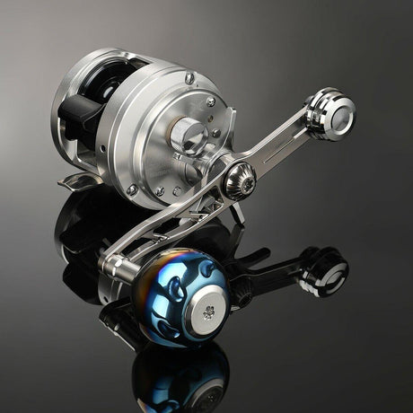 Eine silberne Gomexus Balance Power Handle 7x4mm Baitcastingrolle mit einem Titan-Power-Knopf und einem metallischen, mehrfarbigen Balance-Griff ruht auf einer glänzend schwarzen Oberfläche, ihr zylindrischer Körper ist mit im Licht reflektierenden Einstellknöpfen und Schrauben versehen.