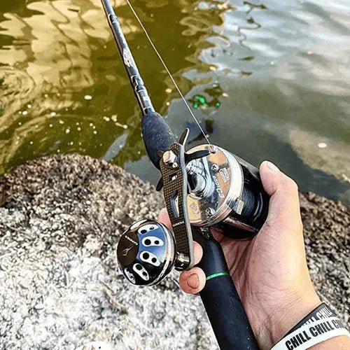 Eine Person greift einen Gomexus Carbon Handle 75 mm mit 38 mm Power Knob (8x5mm), steht über Felsen in trübem Wasser und trägt ein 
