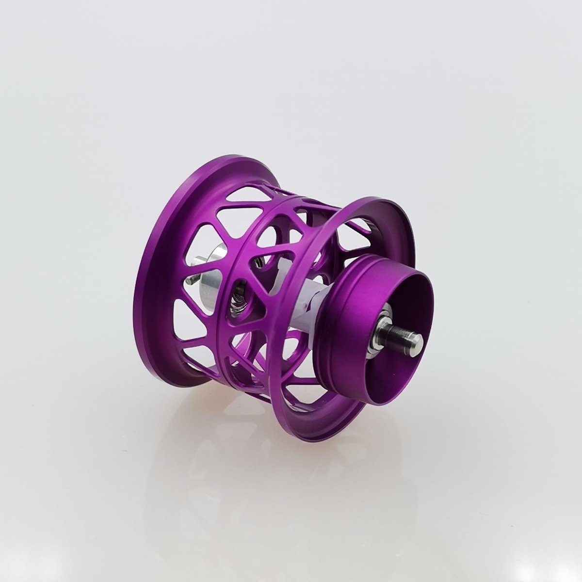 Eine lila Shallow Spool | 21 Alphas von Ray's Studio steht schräg auf einem schlichten weißen Hintergrund und weist ein metallisches Gittermuster mit einer zentralen Achse auf.