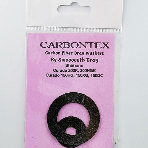 Ein Smoothdrag Bremsscheiben Carbontex-Pack für Shimano Baitcasterrollen enthält zwei schwarze runde Scheiben, die auf einem rosa Hintergrund in einer durchsichtigen Kunststoffverpackung abgebildet sind, und verspricht eine verbesserte Bremskraft für Ihre Angelrolle.