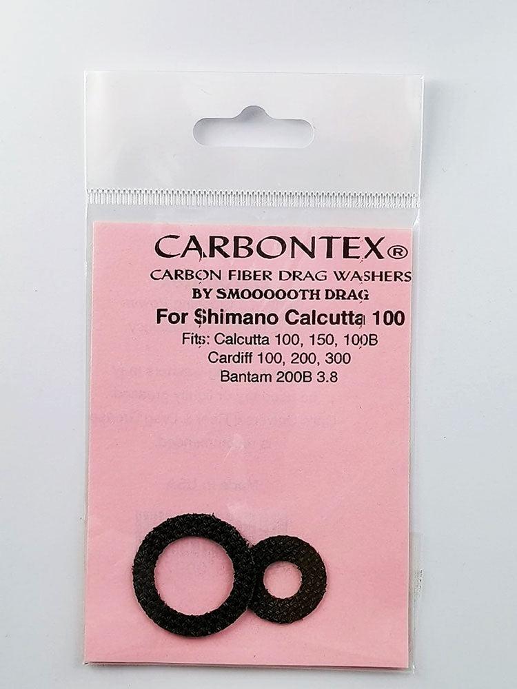Ein Paket mit der Aufschrift Smoothdrag Bremsscheiben Carbontex für Shimano Baitcasterrolle, mit zwei schwarzen Scheiben auf einer rosafarbenen Karte, auf der Produktkompatibilität und Bremskraftdetails angegeben sind.