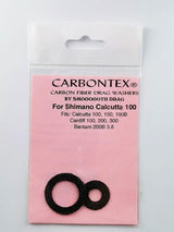 Ein Paket mit der Aufschrift Smoothdrag Bremsscheiben Carbontex für Shimano Baitcasterrolle, mit zwei schwarzen Scheiben auf einer rosafarbenen Karte, auf der Produktkompatibilität und Bremskraftdetails angegeben sind.